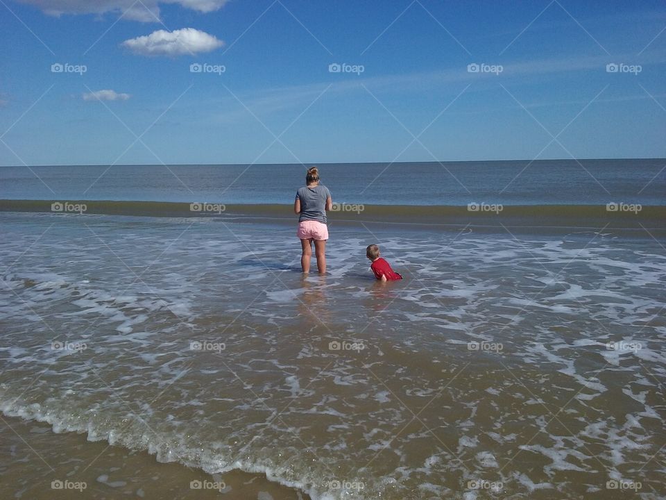 Two people playing at beach in water