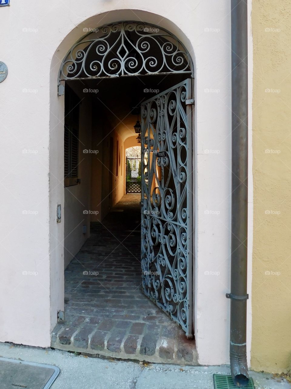 An open gate on the historic Rainbow Row in Charleston, SC, seems to invite you into its hidden courtyard beyond.
