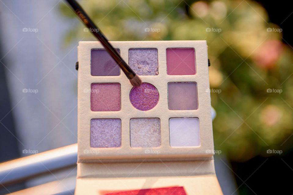 Eye shadow palette on floral background.