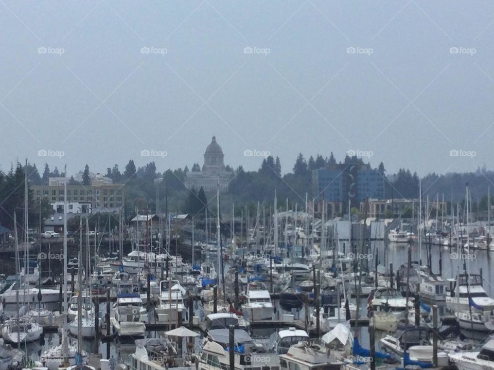 Landscape of the boats of the harbor in Olympia, Washington withe the state capitol building in the background 
