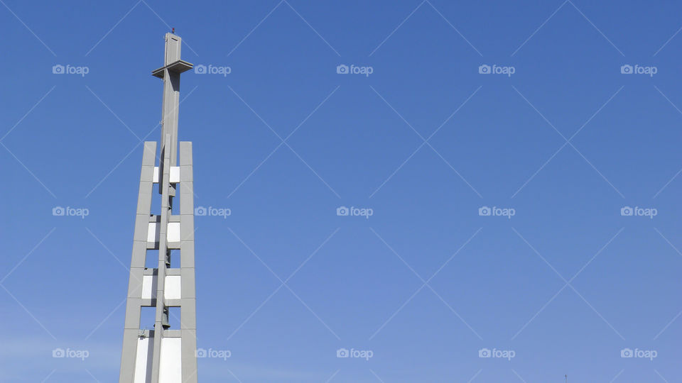 Modern church bell tower, landscape vs blue sky background