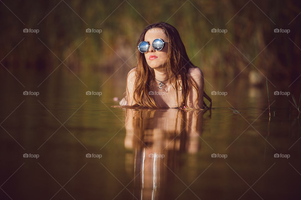 Woman wearing sunglasses in water