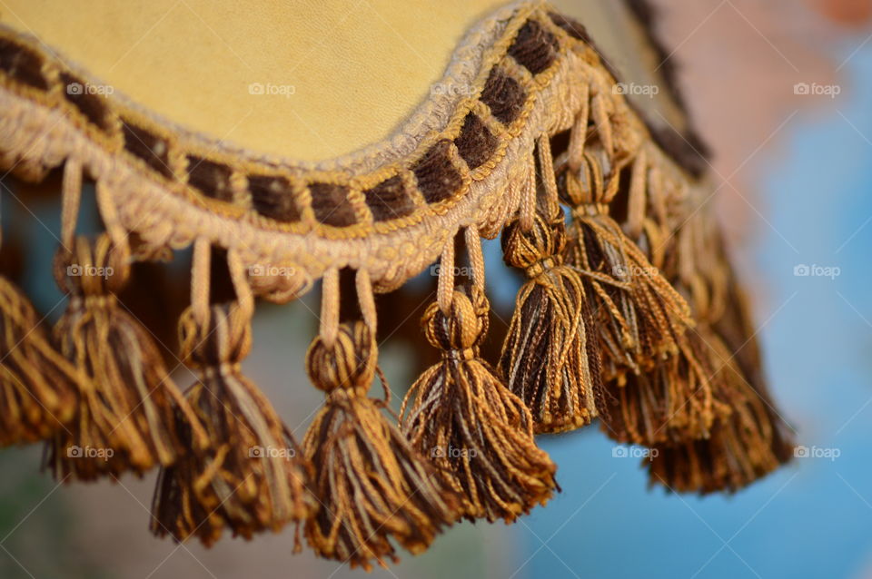 Close-up of curtain tassels against wall