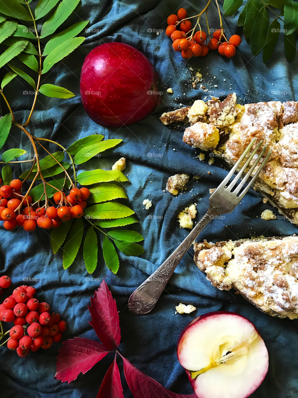 Apple pie decorated by apples, rowan berries and autumn leaves 