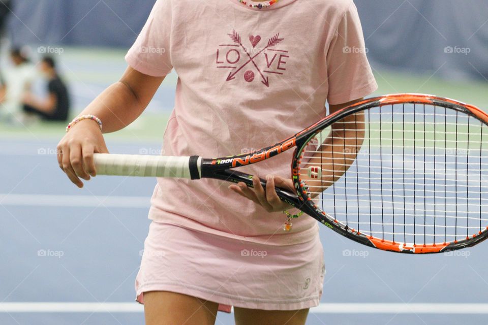 Girl in a pink outfit is playing tennis