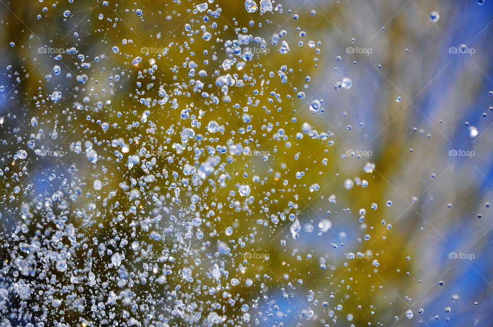 water in motion - drops from fountain on the colorful background