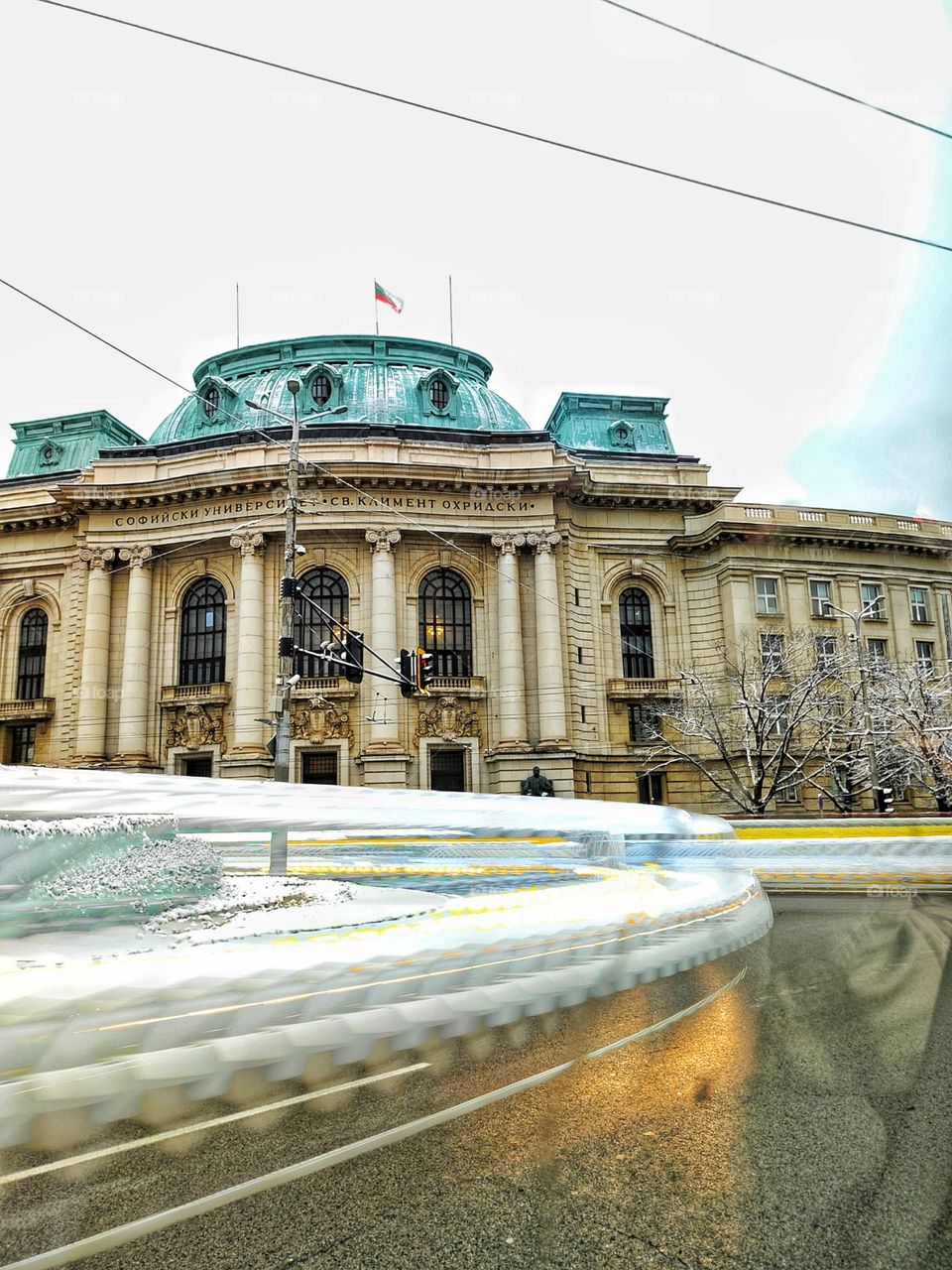 A beautiful scenery in the centre of the capital city of Bulgaria, with its most famous university and neon trails from the passing vehicles in the winter