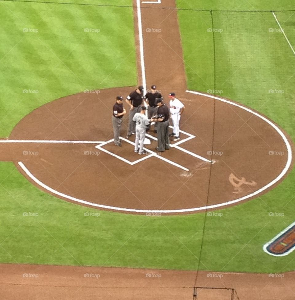 Meeting at home plate. Umpires and managers