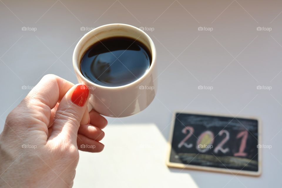 coffee cup in female hand on a white table background