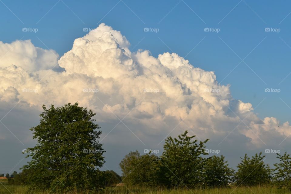 Snow-white clouds in the shape of mountains on a background of blue sky
