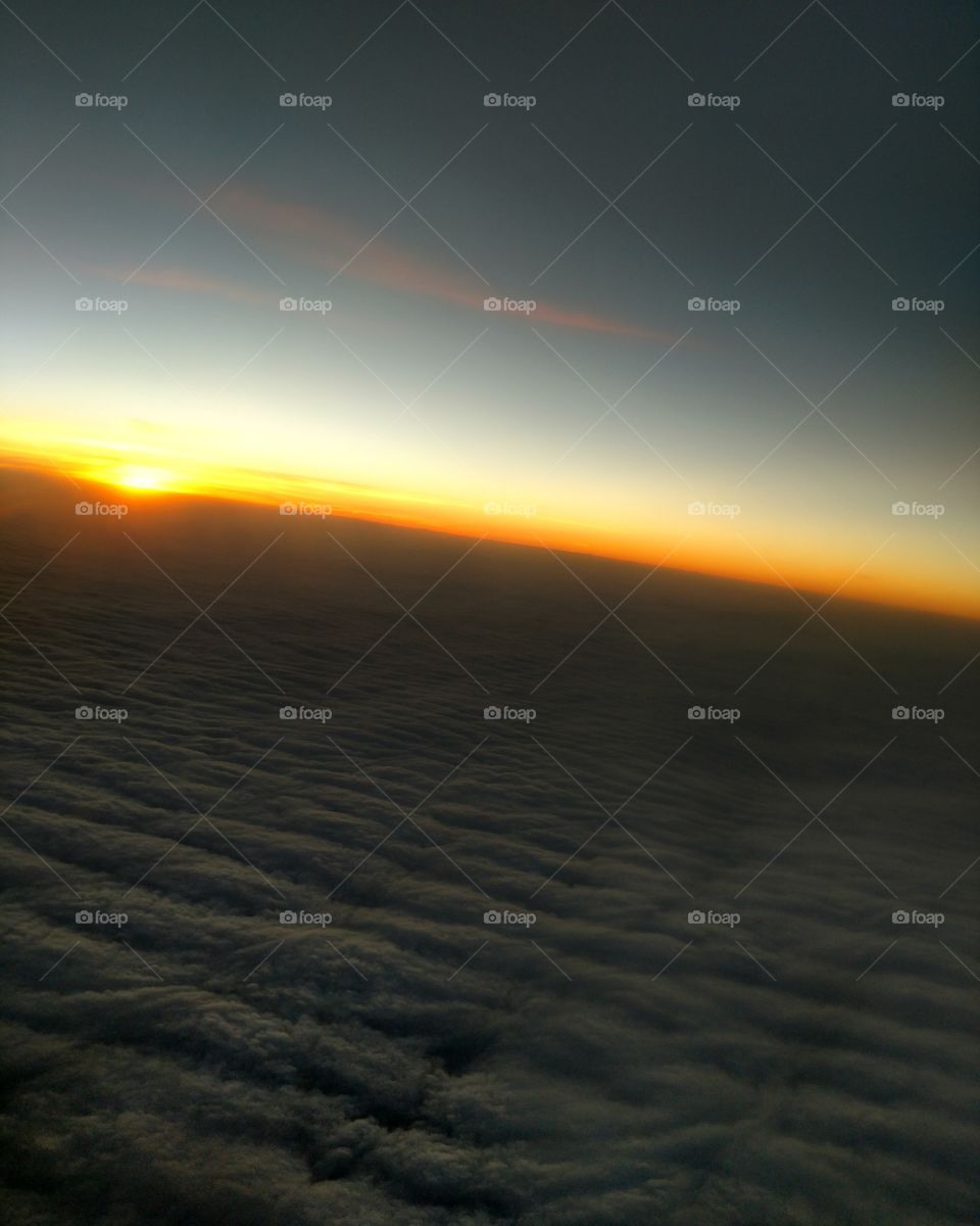 Sunset over waves of clouds