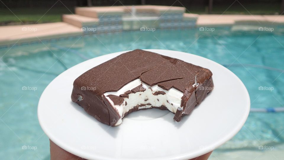 Deliciously cold crunchy and chocolatey ice cream bar poolside on a sunny summer afternoon