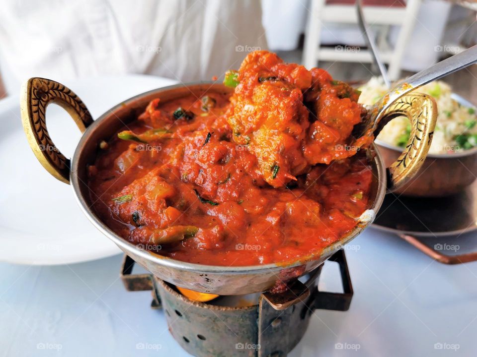 Indian curry on spoon in a bowl. Traditional Indian food.