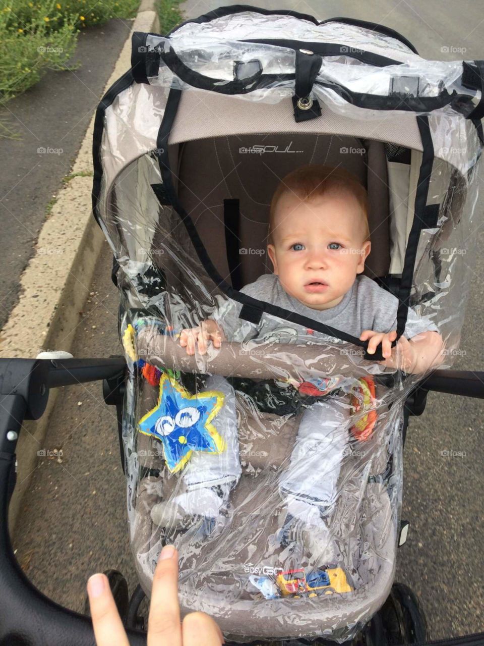 a child in a stroller in the rain