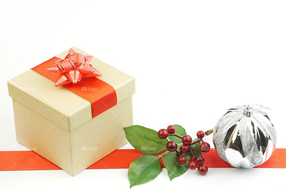 Christmas gift box with ornament and red ribbon stripe on white background