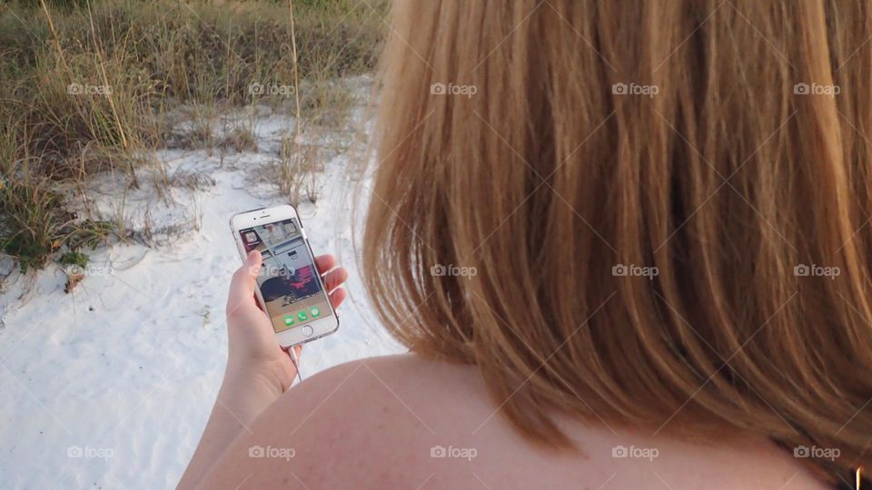 Smartphone at the beach keeps in touch anytime anywhere