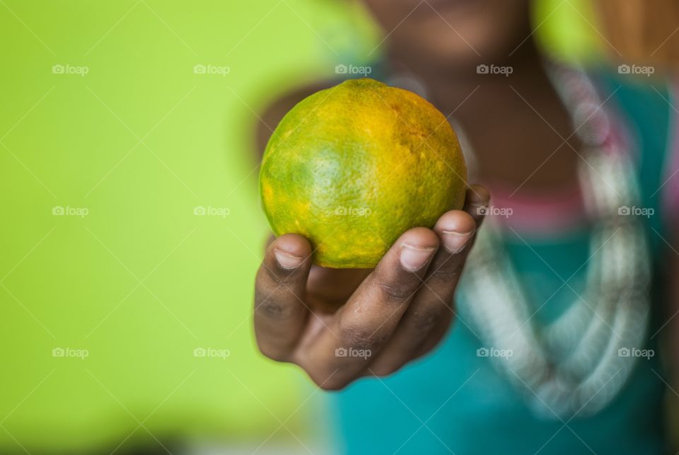 Extreme close-up of orange in hand