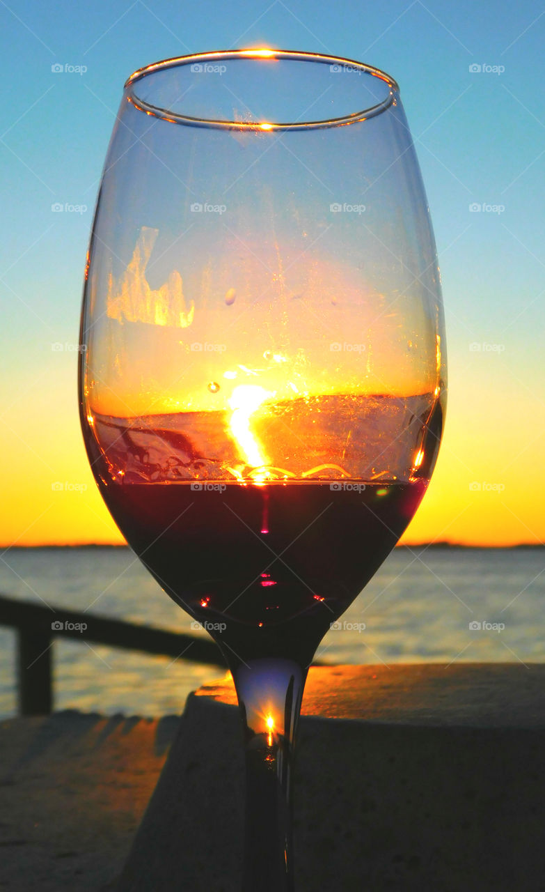 Wine and dine sunset!
A beautiful sunset penetrates the red liquid in this symmetrically shaped glass and casts it shadow in the stem! Nothing more delightful then Mother Natures beauty!