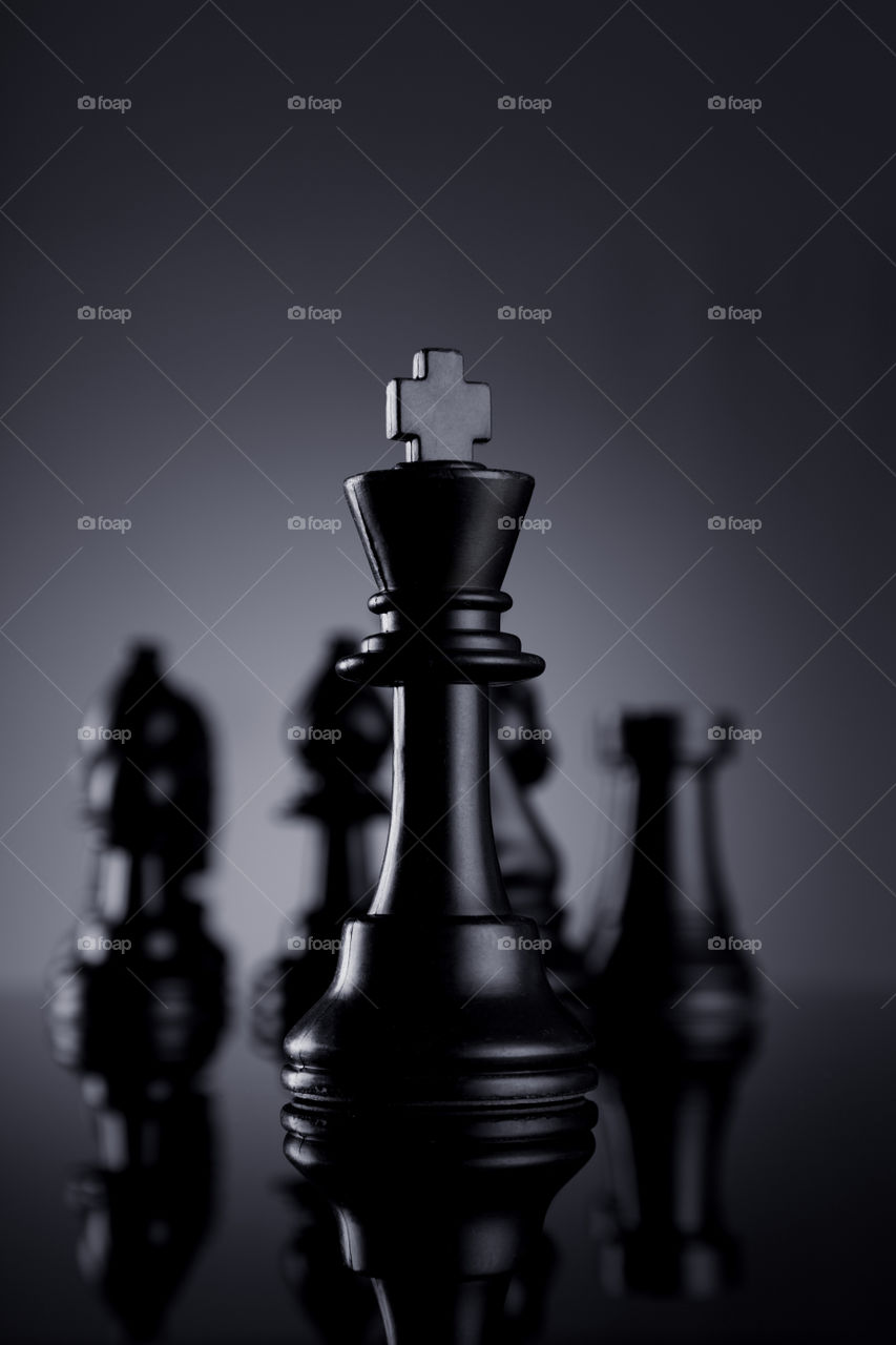 The winner, black chess king on grey background