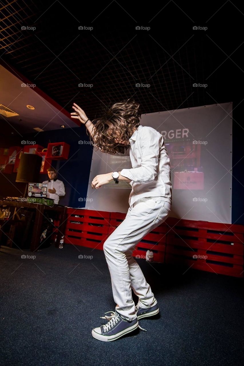 funny moment of a young guy with long hair during the dance enjoying the dance