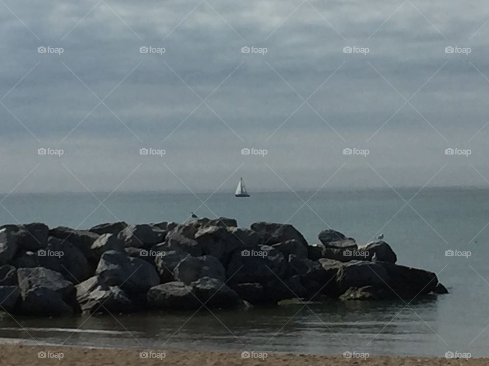 Rocky shoreline with sailboat