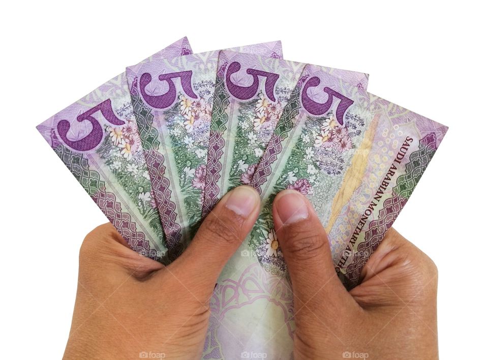 Saudi Arabia 5 Riyal Banknotes in hands.