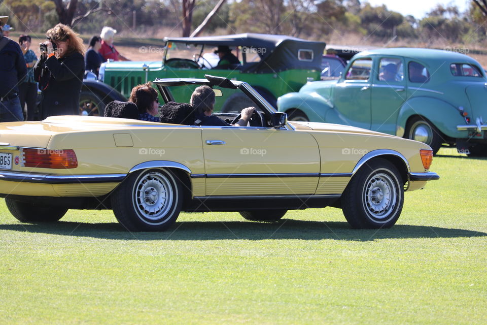 Banana yellow classic convertible car at outdoor car show 