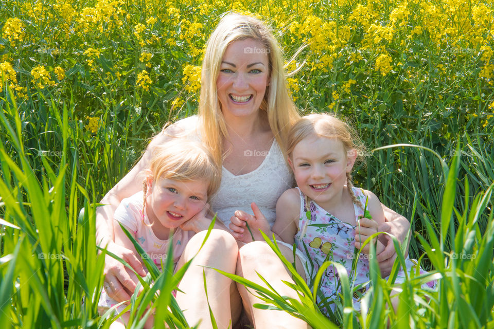 Mother with her two cute doughters posing in a raps field outside Malmö in Sweden.