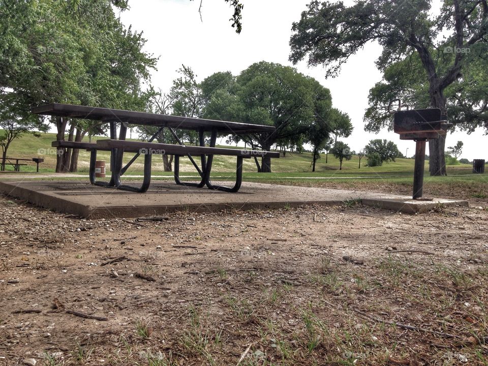 In need of a family. Empty picnic table and grill at a park 