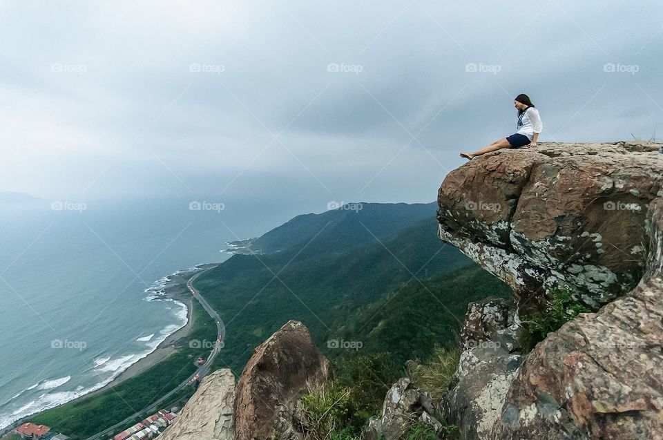 A woman relaxes on a cliff in Yilan, Taiwan. 