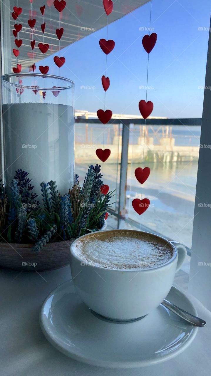 Candle and a cup of coffee on the table 