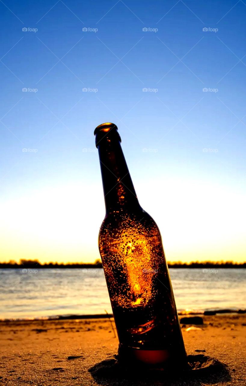 beer bottle on sand nice click sea shore place dark brown bottle