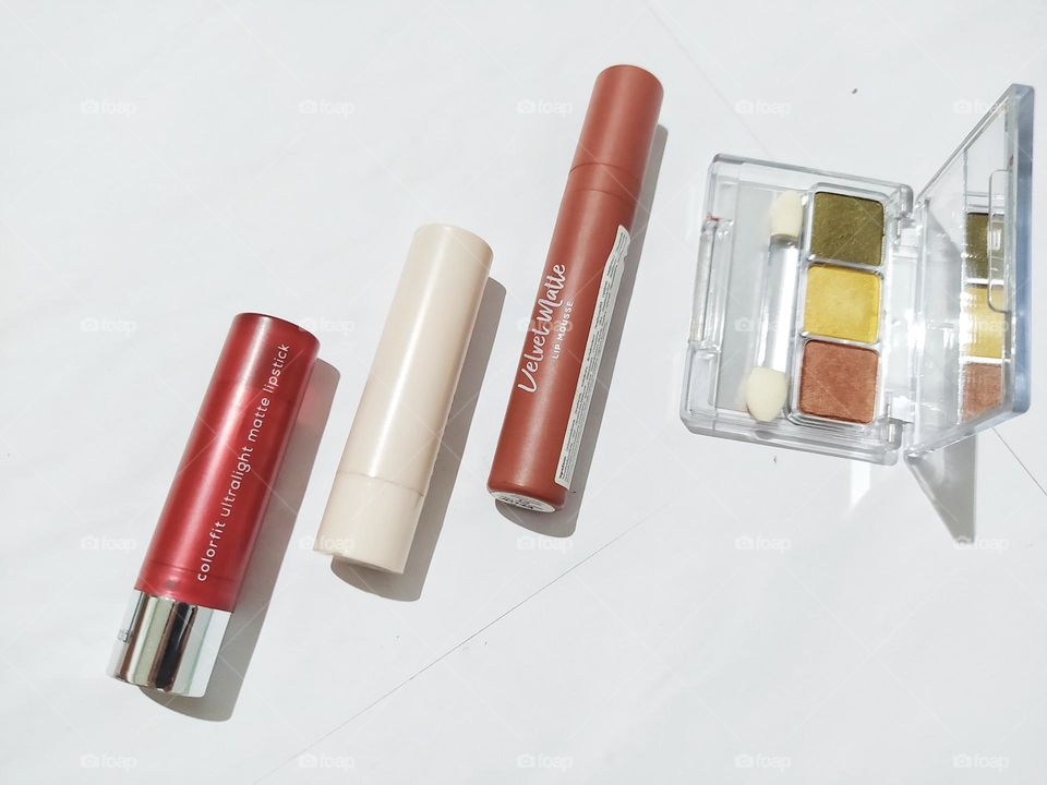 Top view, isolated on white background with some lipstick and eyeshadow kit
