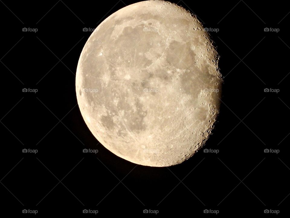 A waxing gibbous moon is in the sky when darkness falls. It lights up the early evening. It appears more than half lighted, but less than full. A waxing gibbous moon comes between first quarter moon and full moon.