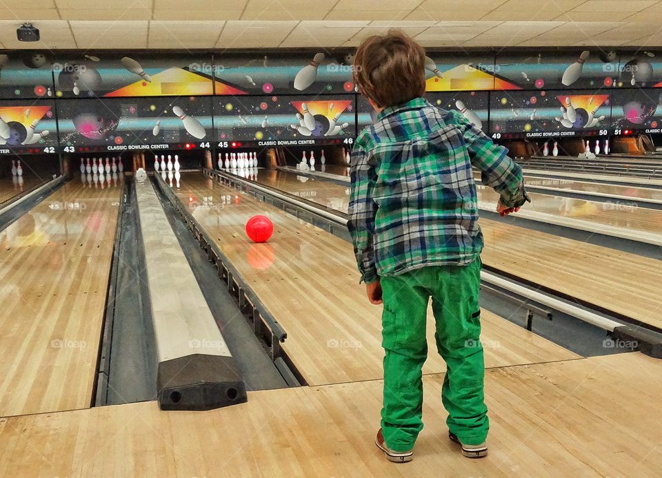 Little Boy Going Bowling. Young Boy At An American Bowling Alley
