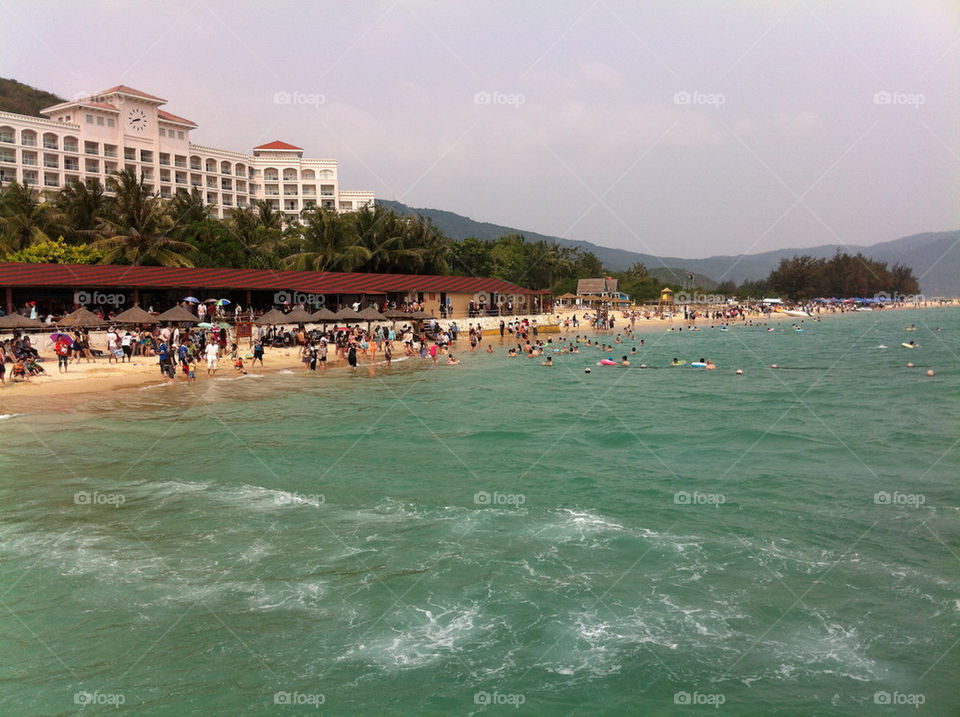 A view of the beach and vacationers having fun.