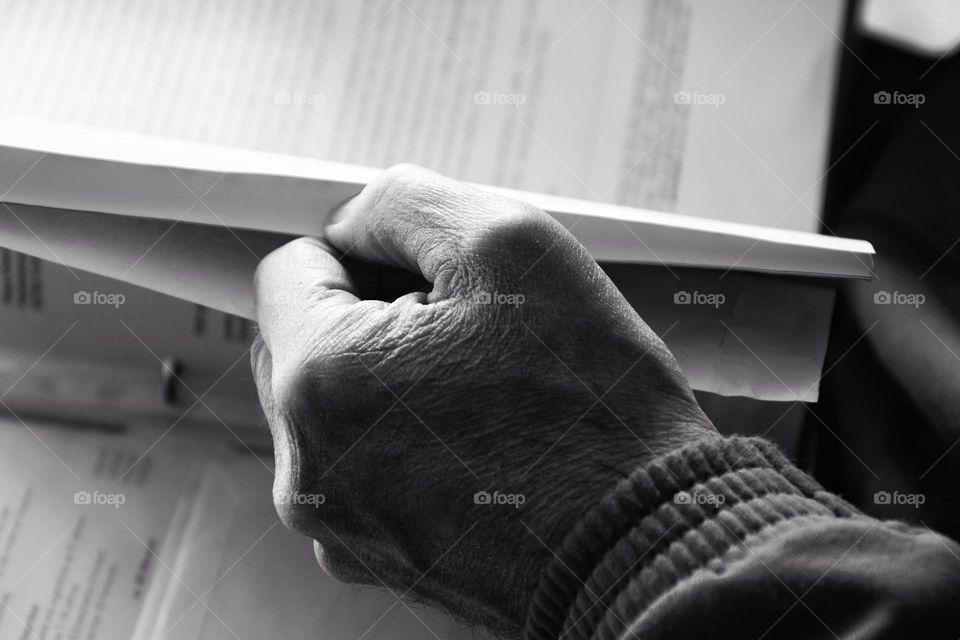 Close-up of a man's hand leafing through a folder