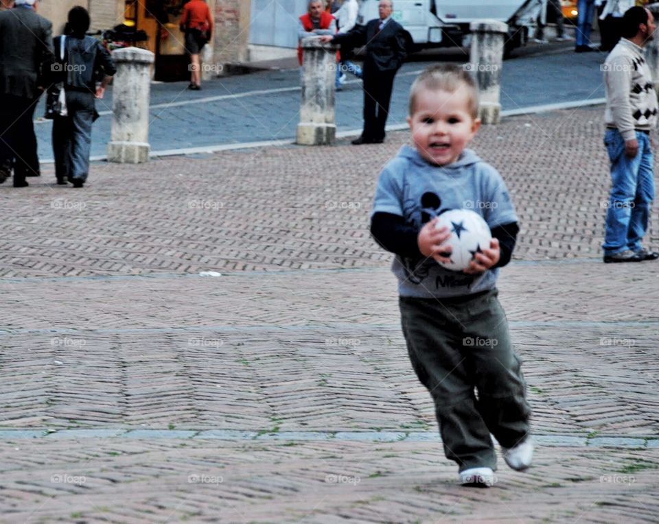 Mine!. A little boy has a joyous look as he gets the ball