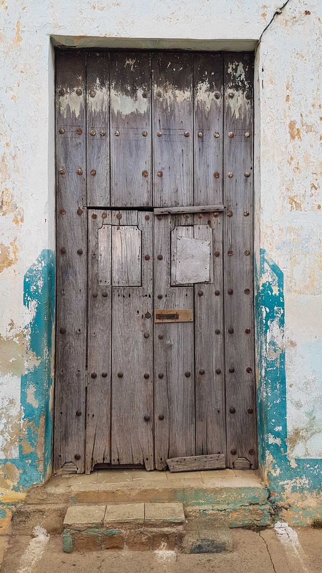 Old wooden door with lots of rusty rivets
