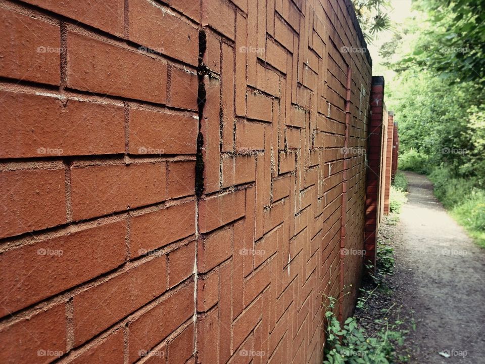 A brick wall in a small alley way near the woodlands at cuerden valley