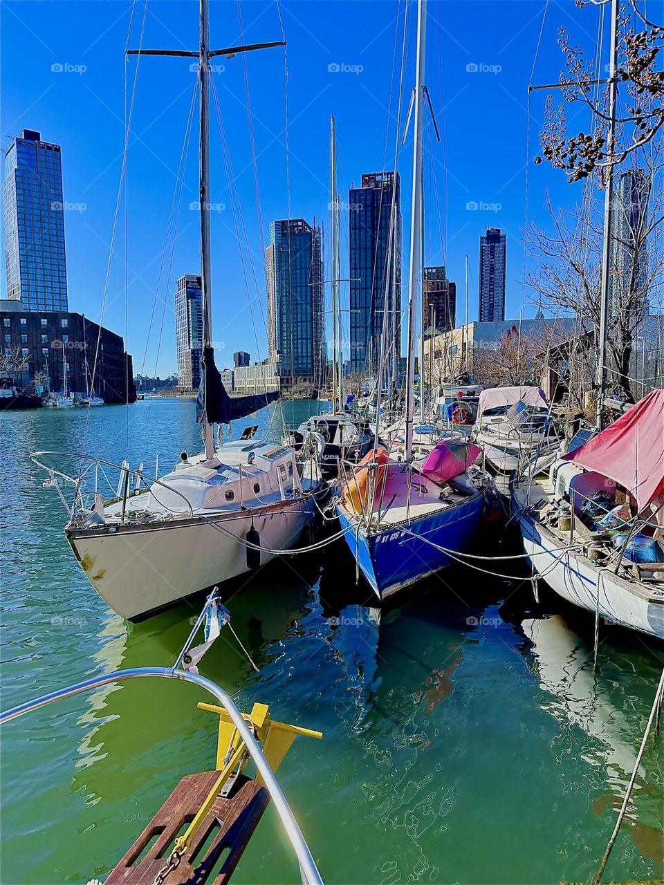 These boats are tied to the LIC shore at “Newtown Creek” by the “Pulaski Bridge”. We are looking out the boat window of “Salvation”, a “28 ft 1969 Luhrs” cabin cruiser that is home to myself and partner “Timothy Trespas”. 2024. Hypnotic Productions