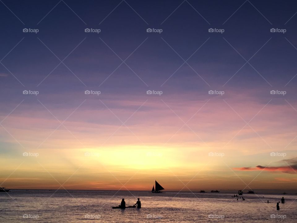 People in sea at sunset