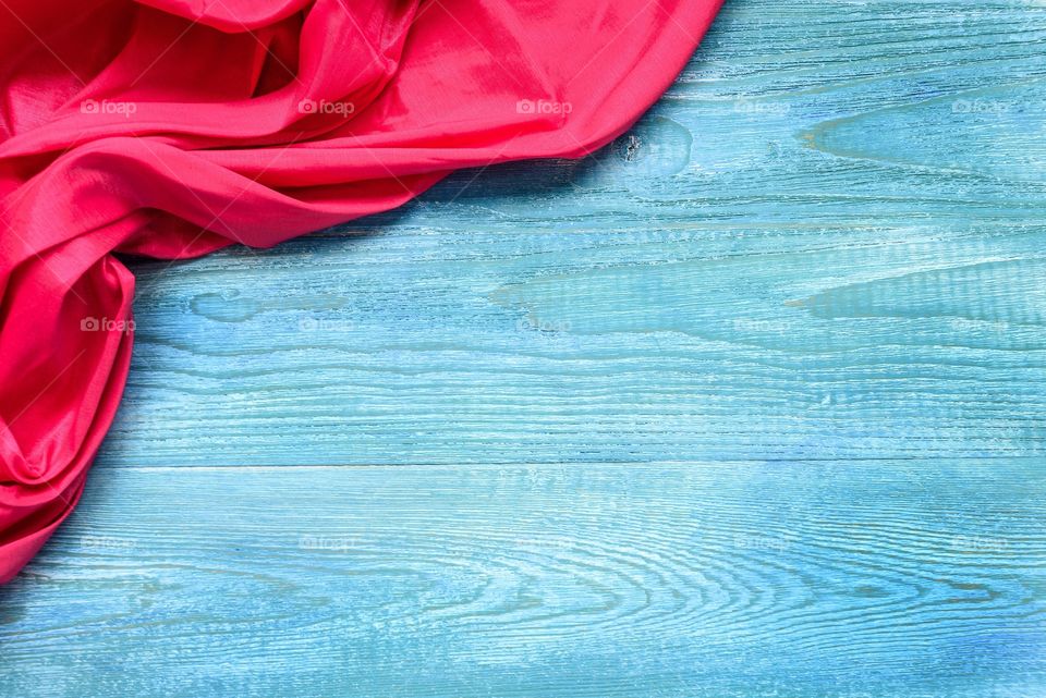 Red napkin on a blue wooden background top view and copy space.