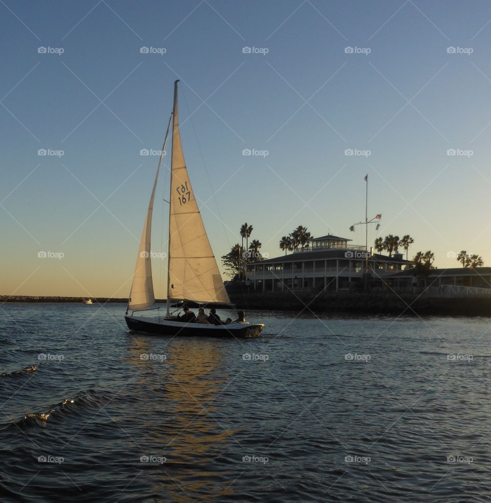 Sailing past yacht club, Long Beach, CA