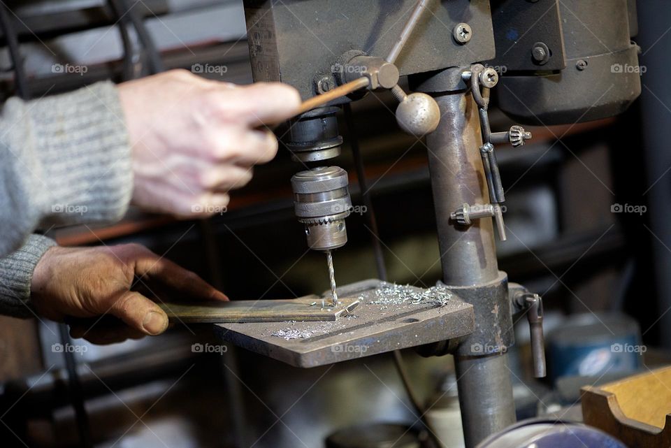 Blacksmith working at with metal at forge