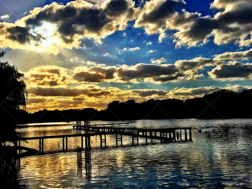 Golden sunset on a lake with jetty