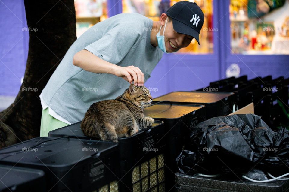 The man is patting the wild cat .