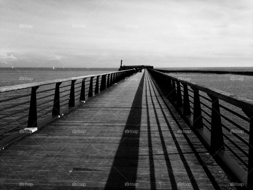 shadow of the railing of a wooden pier on the island of Ye, France