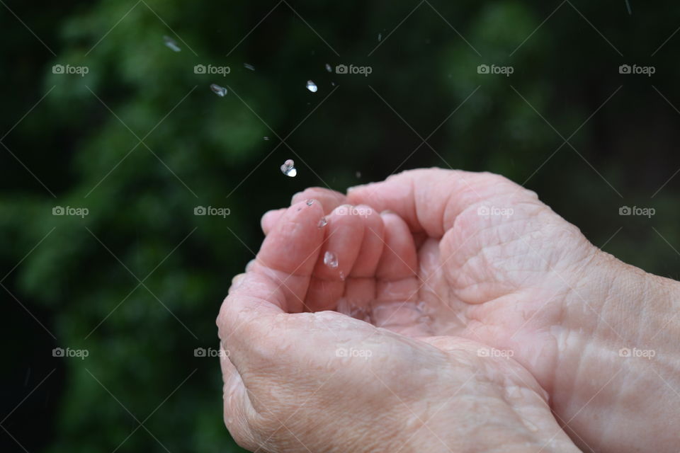 water drops in the hands green background, splash summer time