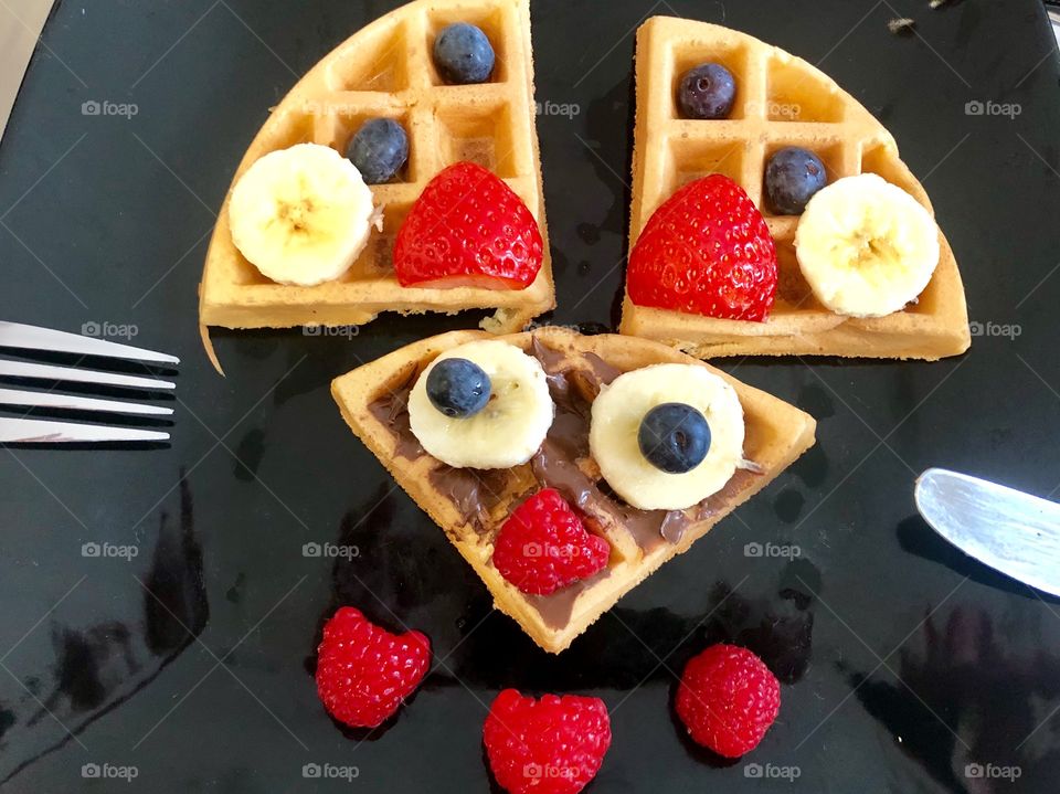 Delicious breakfast of waffles decorated with fruits